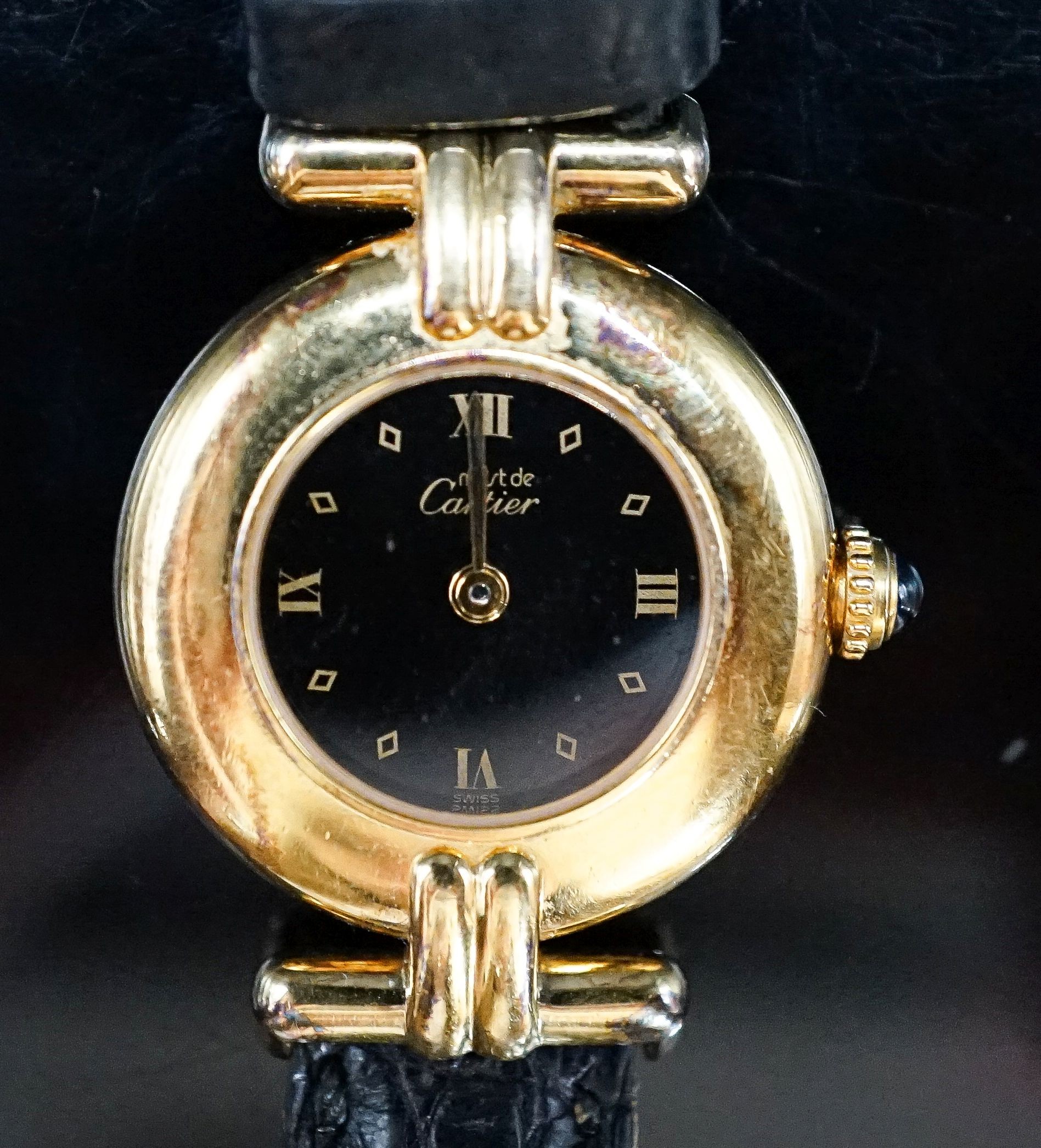 A lady's gilt white metal Must De Cartier quartz wrist watch, on a Cartier leather strap.